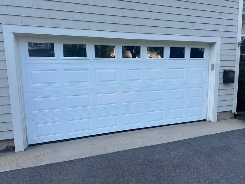 Completed white garage door installation on a Massachusetts home